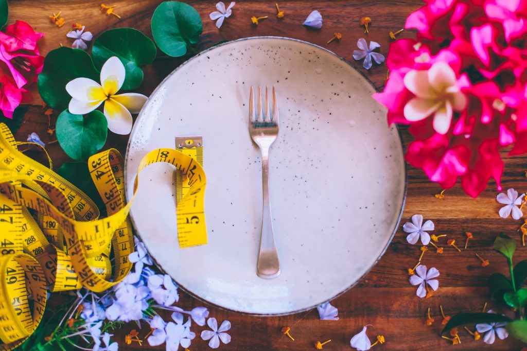 Silver fork lying on a plate with measuring centimeter tape