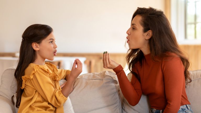 Arabic speech therapist lady working with kid girl pronunciation indoor