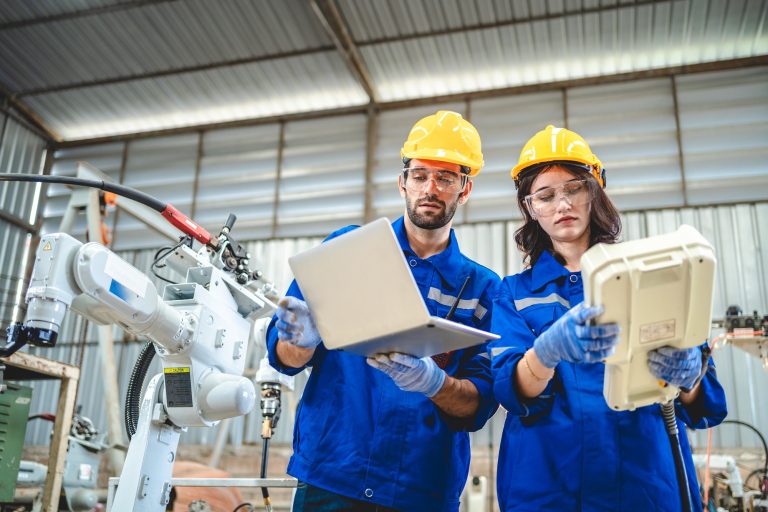 Engineer robot service working in factory, Worker team work to robotic arm software programming