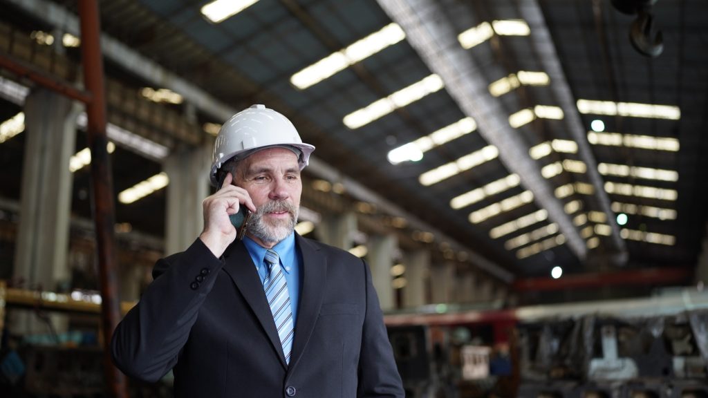 Factory manager or businessman in factory, talking on mobilephone. indusrty Business.