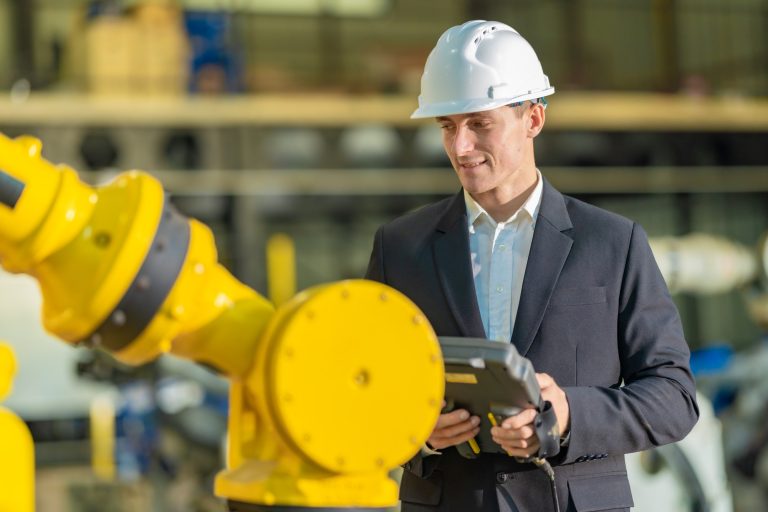 Factory Owner and Manager Inspecting Robotic Arm