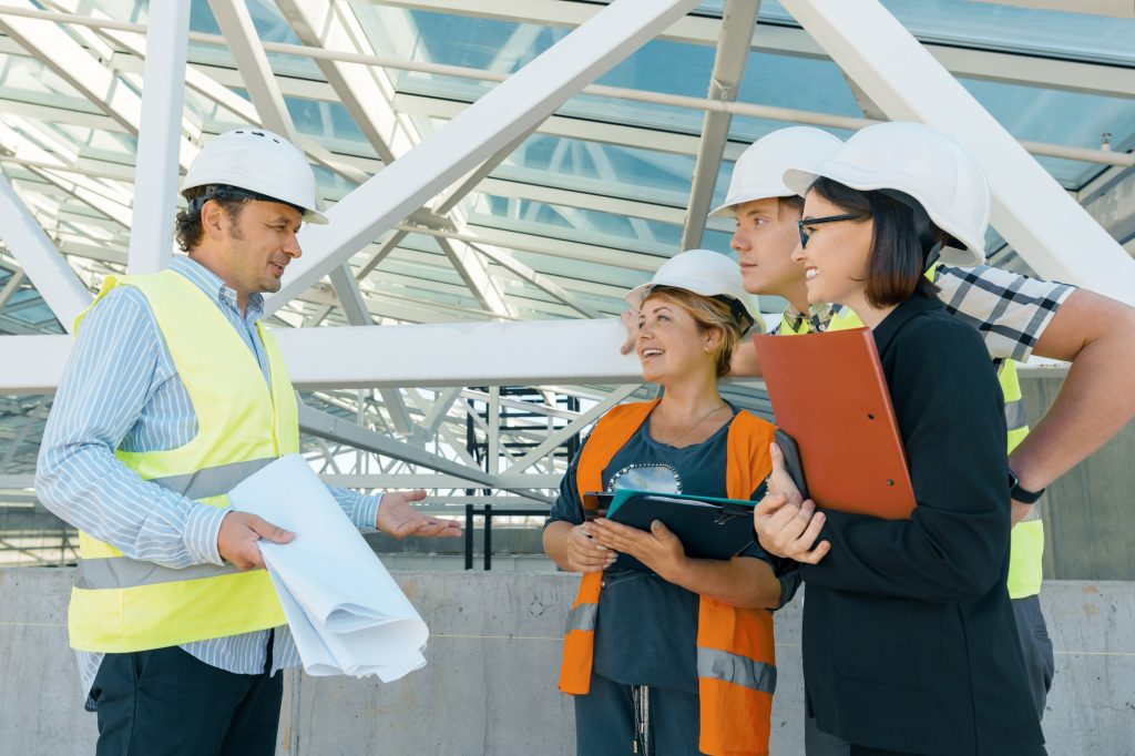 Group of engineers, builders, architects on the building site.