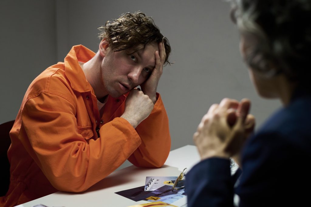 Pensive Male Inmate in Conversation with Another Person