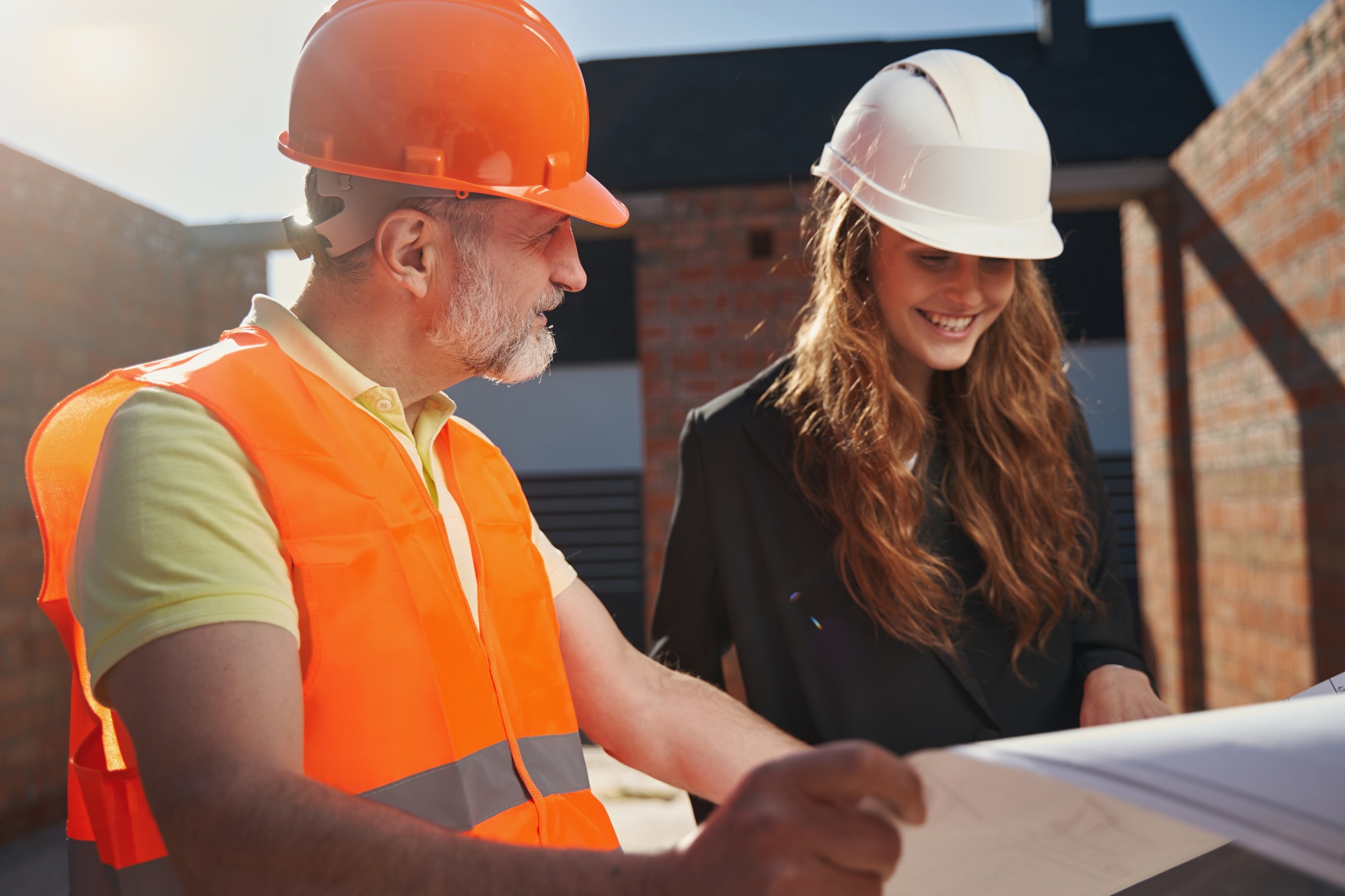 Qualified architects studying the whiteprints of construction object