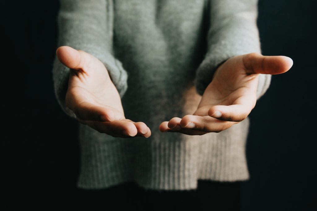 Woman giving hands to the camera, help and self help concept, mental health