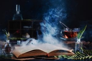 Open spell book with magical smoke