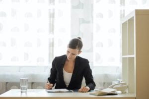 Young businesswoman or lawyer signing document