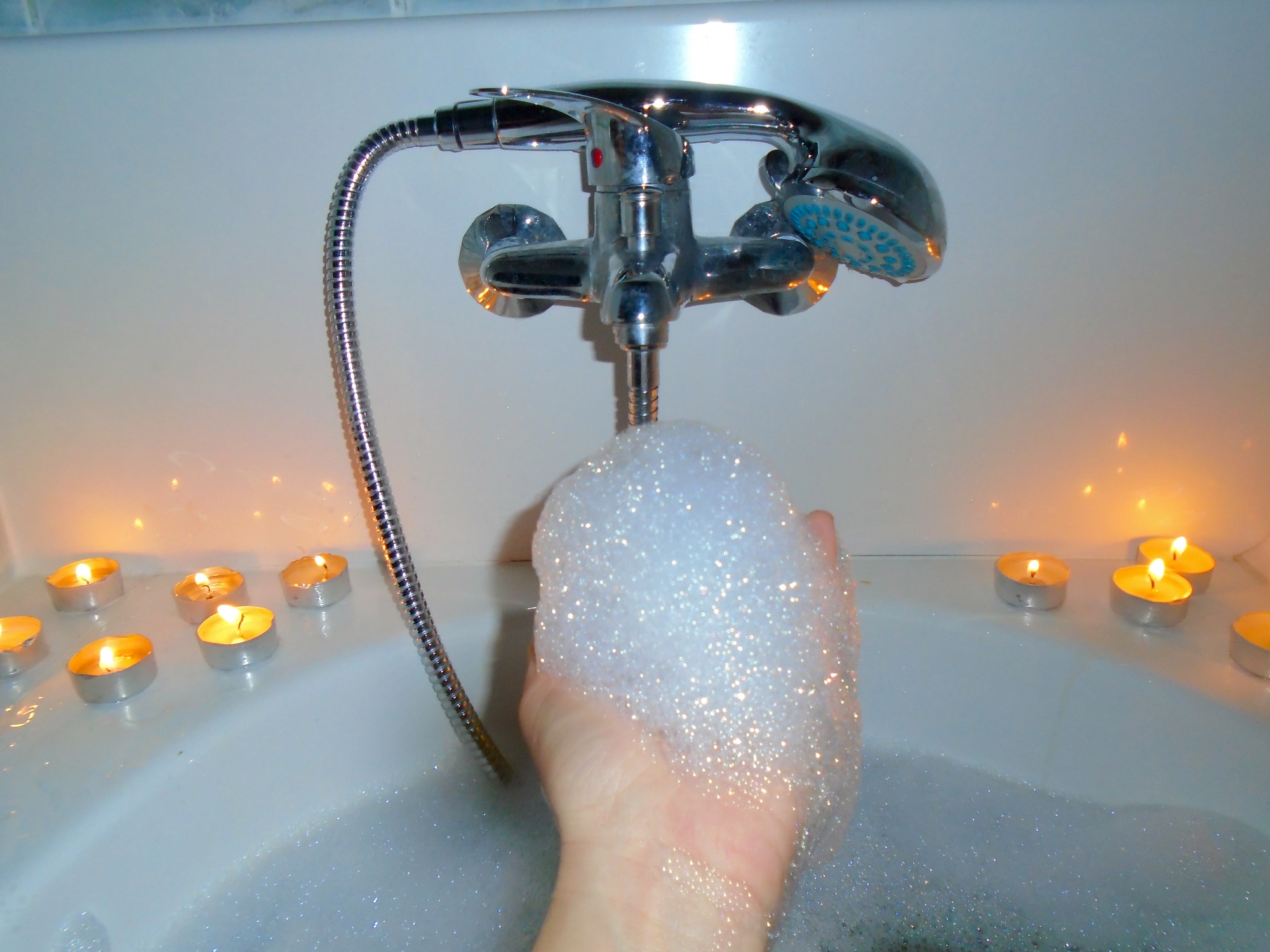 Hand of woman holding foam while taking a bubble bath