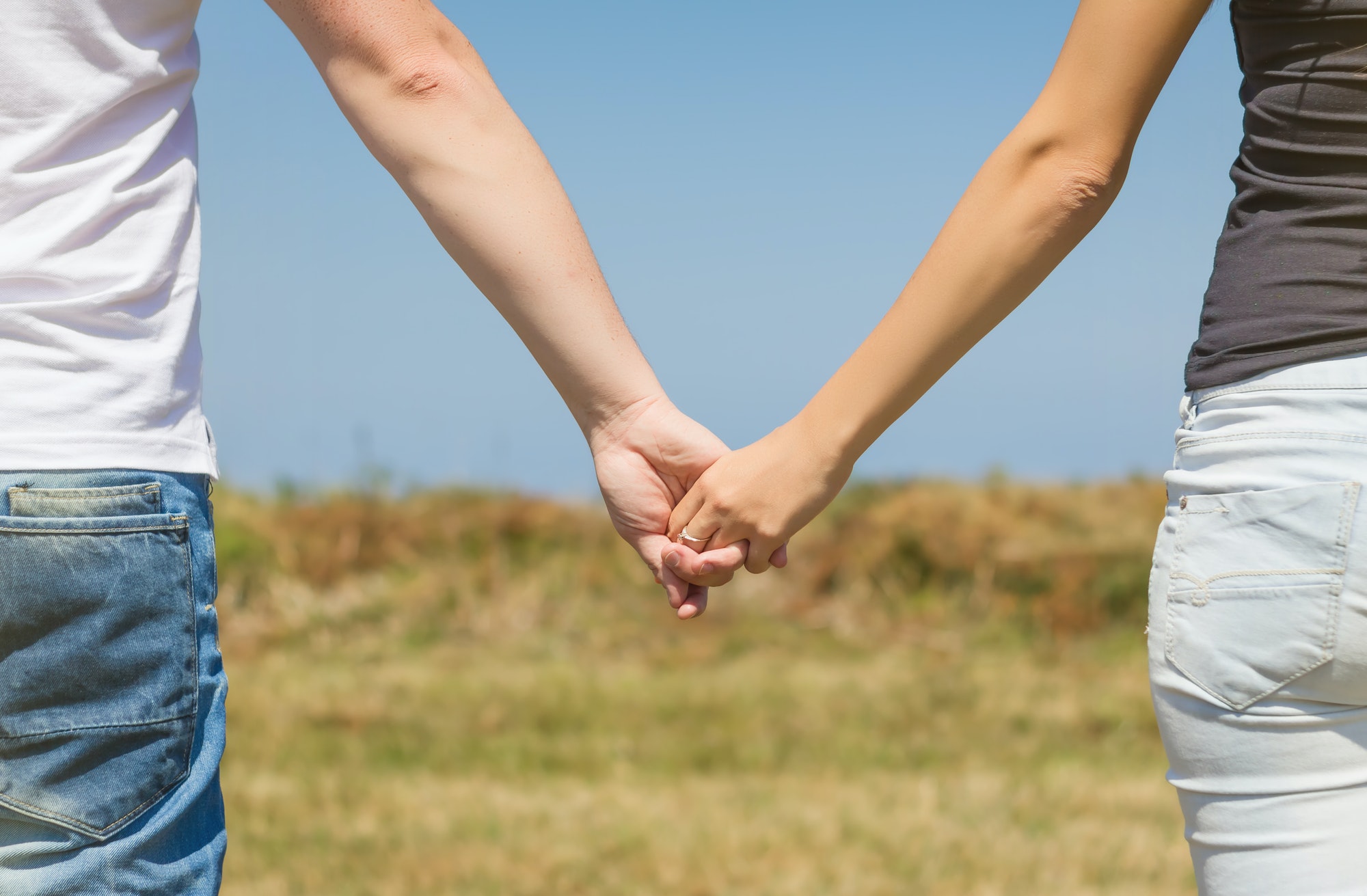 Close up of love couple holding hands outdoors