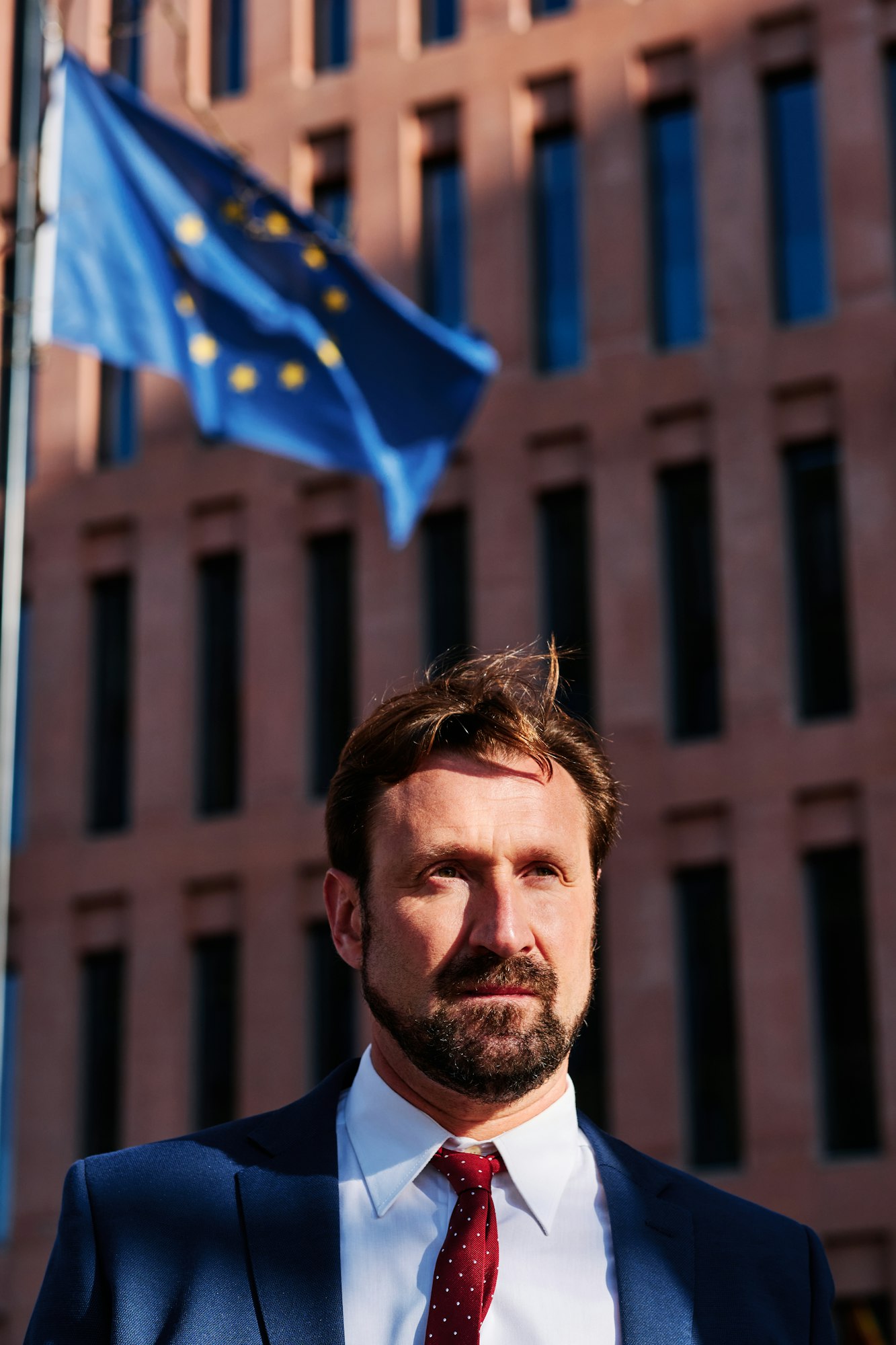 Minister na tle budynku ministerstwa i flagi UE